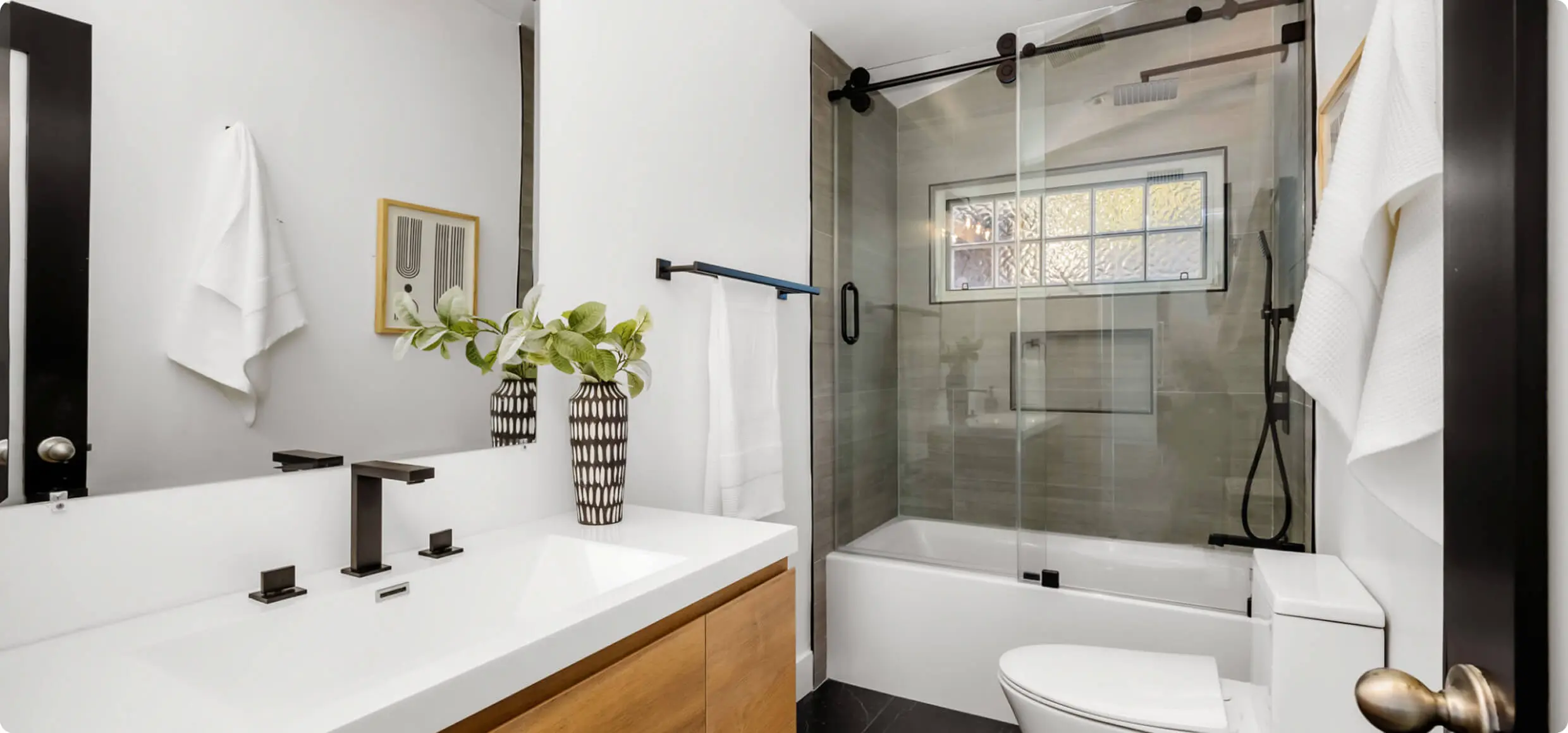 Modern bathroom with glass shower and vanity.