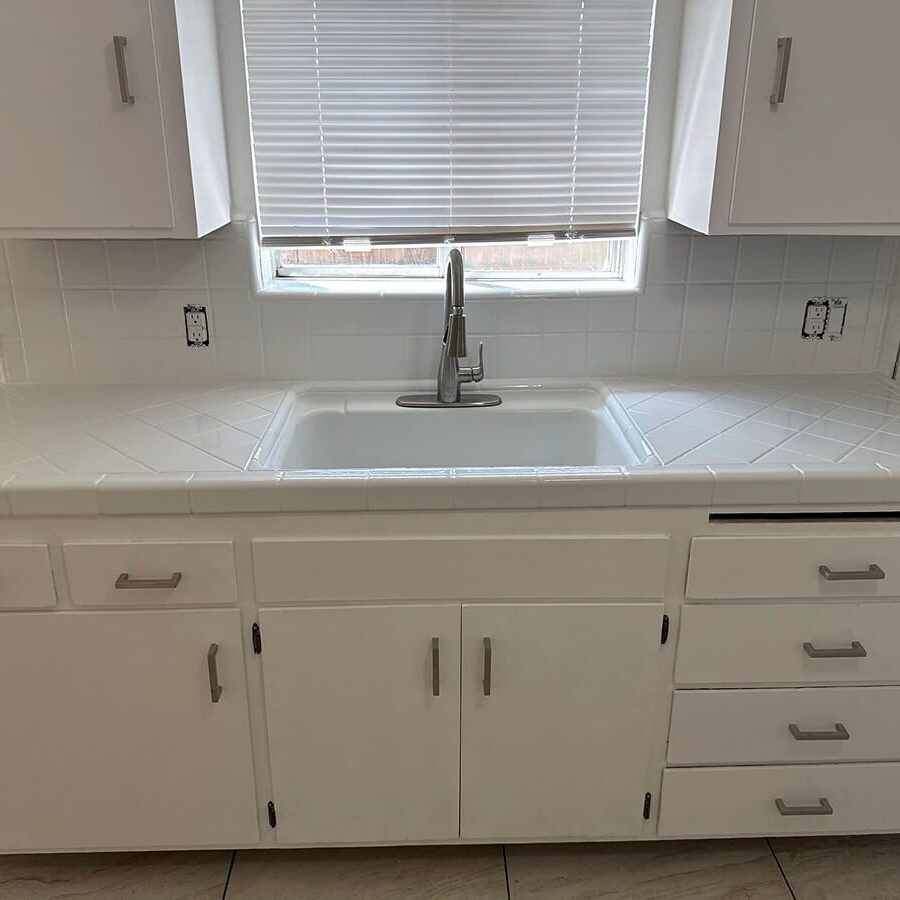 White kitchen sink with cabinets and drawers.